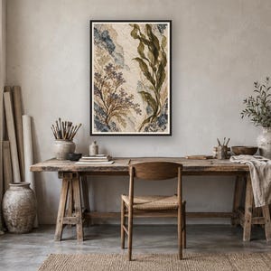 May include: A rectangular framed wall art piece featuring a botanical illustration with tall green seaweed, delicate purple floral sprigs, and textured blue and beige abstract shapes on a light cream background, displayed in a black frame.