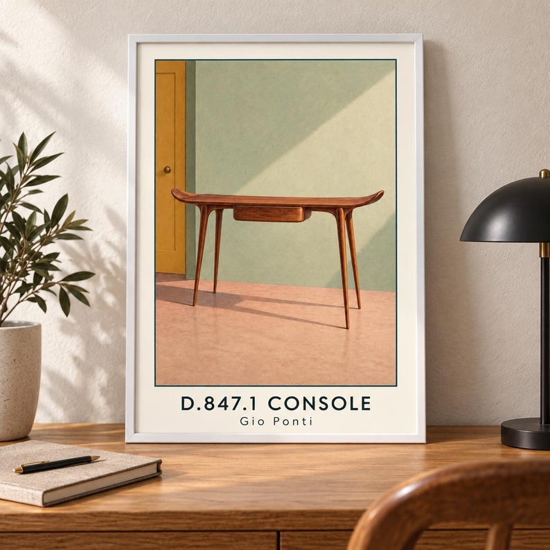 Puede incluir: Una l&aacute;mina art&iacute;stica enmarcada que muestra una mesa consola de madera con un caj&oacute;n y cuatro patas c&oacute;nicas. La mesa est&aacute; situada frente a una pared verde claro y una puerta amarilla, sobre un suelo color melocot&oacute;n. El texto D.847.1 CONSOLE Gio Ponti aparece debajo.