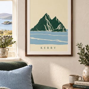 Pu&ograve; includere: Una stampa artistica incorniciata che presenta un'illustrazione stilizzata delle isole Skellig nel Kerry, in Irlanda. L'immagine mostra montagne frastagliate verde scuro e una capanna di pietra su uno sfondo color crema, con acqua blu e il testo KERRY.