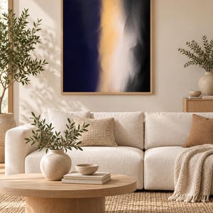 May include: A rectangular wall art piece featuring an abstract composition with a vertical band of soft yellow light transitioning into deep navy blue and black shadows, enclosed within a light-toned wooden frame hanging on a neutral wall.