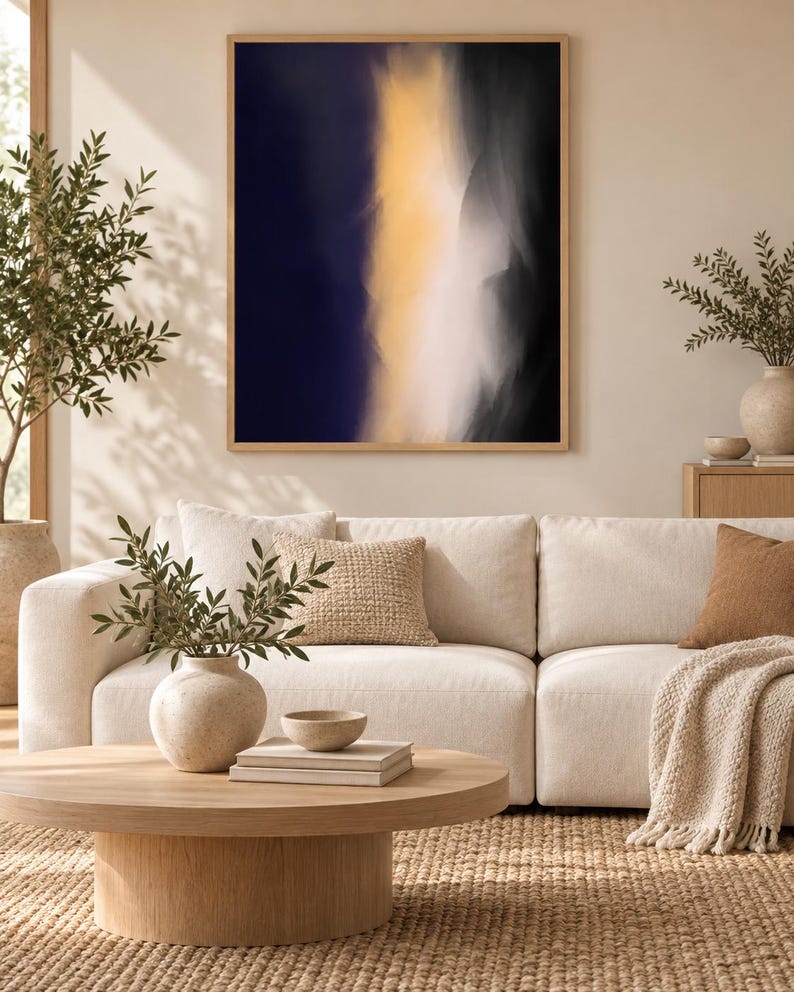 May include: A rectangular wall art piece featuring an abstract composition with a vertical band of soft yellow light transitioning into deep navy blue and black shadows, enclosed within a light-toned wooden frame hanging on a neutral wall.