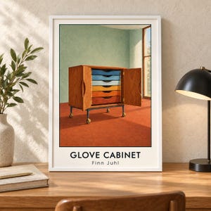 May include: A framed art print titled GLOVE CABINET by Finn Juhl, depicting a wooden cabinet with open doors revealing six colourful drawers in blue, yellow, and orange hues, set on a wheeled metal base against a light green wall and orange floor.