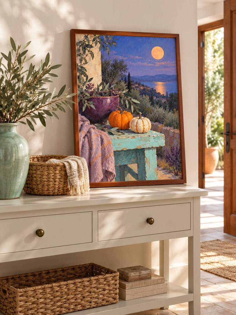 May include: A framed wall art print depicting a Mediterranean landscape at twilight with a full moon over the sea. The scene features a weathered turquoise table holding a purple bowl, olive branches, and two pumpkins, with a lavender cloth draped nearby.