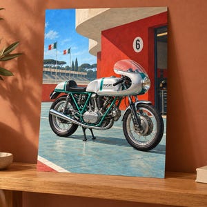Puede incluir: Una motocicleta Ducati vintage de color plata y verde estacionada en una pista azul frente a un edificio rojo con el n&uacute;mero 6 en la pared. La motocicleta cuenta con un carenado redondeado, ruedas de radios y un tubo de escape cromado.