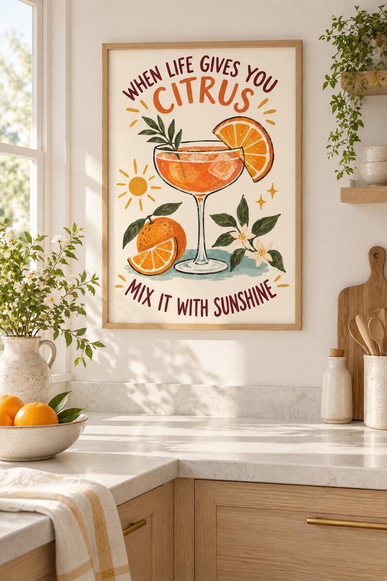 May include: A framed wall art print featuring a cocktail glass filled with an orange liquid, ice cubes, and a citrus slice. The text reads, "WHEN LIFE GIVES YOU CITRUS MIX IT WITH SUNSHINE." The illustration includes a whole orange, leaves, and a sun.