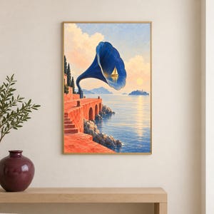 May include: A framed wall art print depicting a surreal coastal scene with a large blue gramophone horn emerging from a red stone terrace. Inside the horn, a small sailboat floats on water. The background shows a calm sea, distant mountains, and a sunset.