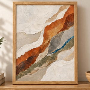 May include: A framed abstract wall art piece featuring layered, torn-paper style textures in shades of burnt orange, cream, sage green, gray, and a thin streak of deep blue. The artwork is encased in a light-toned wooden frame with a clean finish.