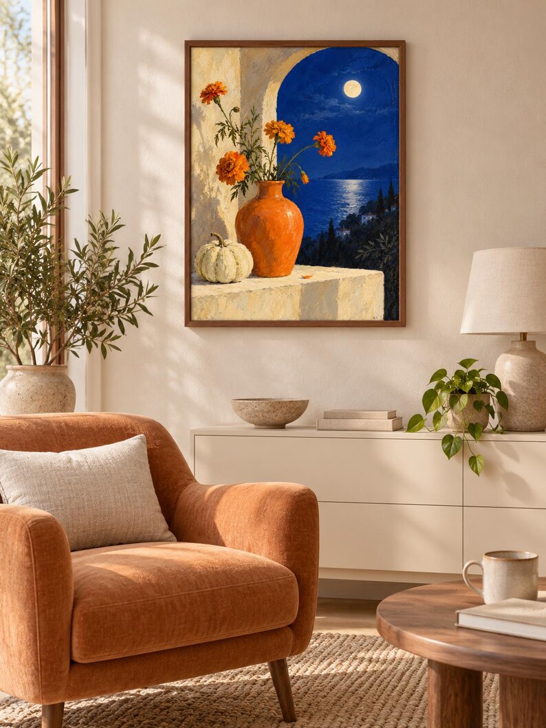 Puede incluir: Una impresi&oacute;n de arte mural enmarcada que representa un bodeg&oacute;n con un jarr&oacute;n de cer&aacute;mica naranja lleno de flores de cal&eacute;ndula naranjas y una calabaza blanca sobre una repisa, ante un paisaje nocturno con luna llena sobre un mar azul oscuro.