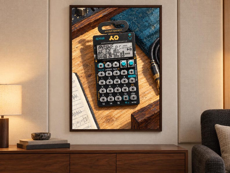 Puede incluir: Un sintetizador de bolsillo negro Teenage Engineering PO-35 speak que presenta una pantalla LCD monocrom&aacute;tica con el texto "Form" y personajes de dibujos animados, una cuadr&iacute;cula de botones plateados, dos perillas color cerceta y un colgador de pl&aacute;stico.