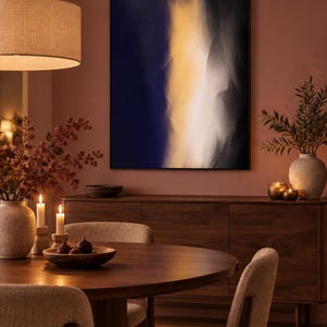 May include: A rectangular wall art piece featuring an abstract composition with a vertical band of bright yellow light transitioning into deep navy blue and black shadows, framed in a thin black border and mounted on a muted terracotta wall.