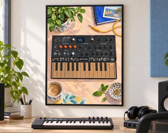 Op de afbeelding: Een ingelijste kunstdruk met een Arturia MicroFreak synthesizer met een zwarte behuizing, oranje knoppen en een getextureerd bruin toetsenbord. De illustratie bevat een plant in een pot, een blauw notitieboek, een kopje koffie en paperclips.