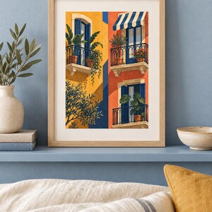 May include: A framed art print featuring a vertical illustration of Mediterranean-style building facades in vibrant yellow and orange. The scene depicts multiple balconies with blue shutters, black railings, potted plants, and a blue and white striped awning.