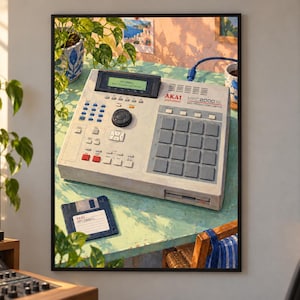 May include: An Akai MPC2000XL MIDI production center with a light gray casing, a grid of square pads, a central dial, and a digital display screen. A blue floppy disk labeled Akai sits on the table next to the music production hardware unit.