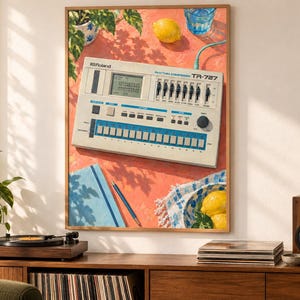 May include: A framed art print featuring a Roland TR-727 Rhythm Composer drum machine on a coral-coloured surface. The illustration includes a lemon, a blue glass of water, a blue notebook with a pen, and a bowl with lemons on a patterned cloth.