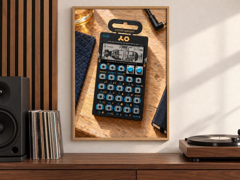 Op de afbeelding: Een zwarte pocket operator synthesizer met een digitaal LCD-scherm met een onderzeebootafbeelding, twee blauwe knoppen en een raster van genummerde knoppen met blauwe labels. Het apparaat bevat de tekst sub en het Teenage Engineering logo.