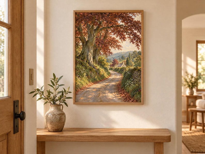 Puede incluir: Una impresi&oacute;n de arte mural rectangular enmarcada que presenta una pintura de paisaje de un camino de tierra que serpentea a trav&eacute;s de una escena rural con grandes &aacute;rboles con follaje oto&ntilde;al en tonos naranja y marr&oacute;n, hierba verde y un muro de piedra.