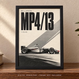 May include: A framed poster featuring a side profile of a McLaren MP4/13 Formula One race car. The design includes the text "McLAREN", "MP4/13", and "1998" in bold black lettering against a cream background with diagonal gray stripes.