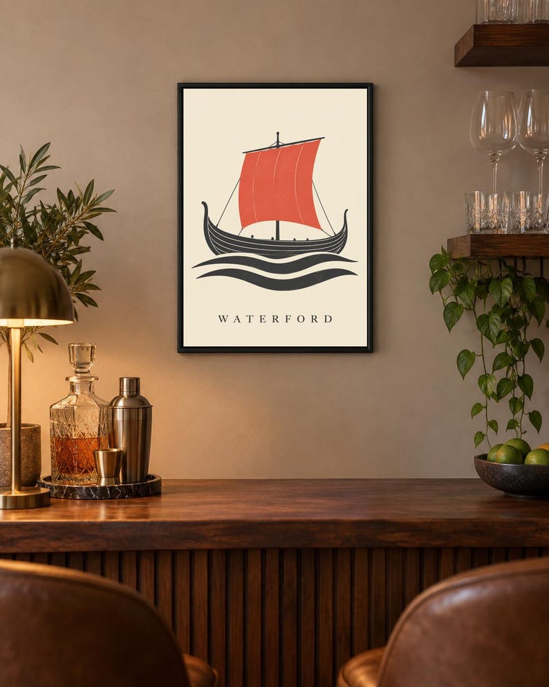 Pode incluir: Uma impress&atilde;o art&iacute;stica emoldurada com um navio viking preto estilizado com uma vela vermelha vibrante sobre um fundo creme. A ilustra&ccedil;&atilde;o mostra o navio sobre linhas escuras e onduladas, com a palavra WATERFORD impressa abaixo.