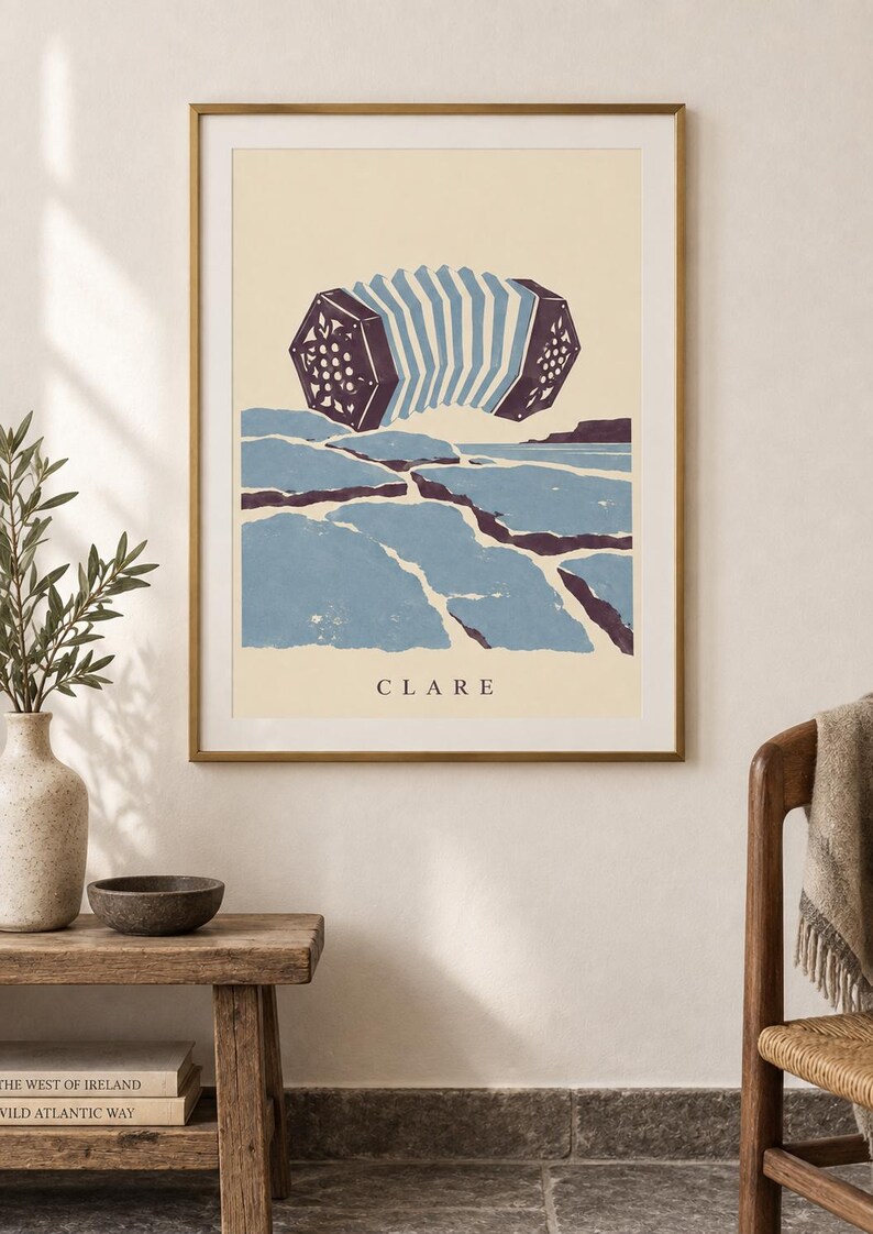 May include: A framed wall art print featuring a stylized illustration of a concertina musical instrument floating above a blue and dark purple landscape. The word CLARE is printed in black capital letters at the bottom of the cream-colored background.