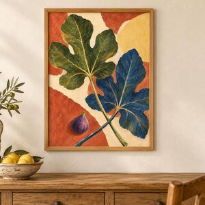 May include: A framed wall art print featuring a large green fig leaf and a large blue fig leaf overlapping on a background of abstract terracotta and cream shapes, with a single small purple fig fruit positioned in the lower left corner.