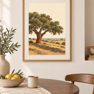 Op de afbeelding: Een ingelijste wandkunstprint met een landschapsillustratie van een grote kurkeik met een roodbruine stam in een goudkleurig veld. De sc&egrave;ne bevat glooiende heuvels, bomen in de verte en een klein wit gebouw onder een bleke lucht.