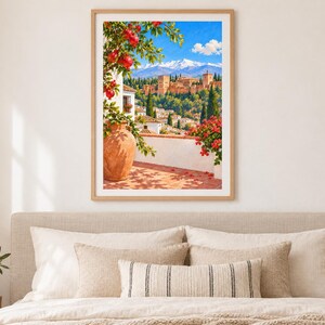 May include: A framed wall art print depicting a sunlit Mediterranean terrace with a large terracotta vase, a pomegranate tree with red fruit, and a view of a historic fortress complex set against snow-capped mountains under a bright blue sky.