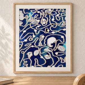 Puede incluir: Una l&aacute;mina de arte mural enmarcada con un dise&ntilde;o abstracto sobre un fondo azul marino profundo, superpuesto con intrincadas l&iacute;neas beige sinuosas y acentos circulares blancos dispersos, todo en un marco de madera clara.