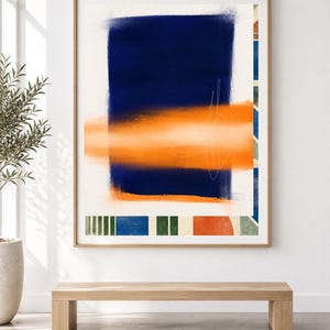 K&ouml;nnte beinhalten: Ein gerahmter abstrakter Wandkunstdruck mit einem gro&szlig;en vertikalen dunkelblauen Rechteck, das von einem horizontalen orangefarbenen Band &uuml;berlagert wird. Die Komposition enth&auml;lt feine wei&szlig;e Linienskizzen und eine untere Bord&uuml;re aus Bl&ouml;cken.