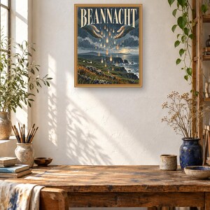 Puede incluir: Una impresi&oacute;n de arte mural rectangular enmarcada titulada BEANNACHT que presenta una ilustraci&oacute;n de dos manos extendidas una hacia la otra sobre un paisaje costero. Gotas doradas brillantes caen de las manos hacia un acantilado y el oc&eacute;ano.