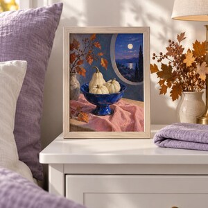 May include: A framed painting depicting a blue pedestal bowl filled with three white pumpkins, set on a pink cloth. Beside the bowl is a vase with autumn leaves. The background shows a circular window view of a moonlit landscape at night.
