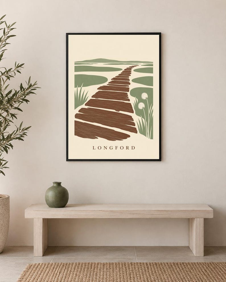 Puede incluir: Una l&aacute;mina de arte mural enmarcada que presenta una ilustraci&oacute;n de paisaje estilizada de un camino de madera marr&oacute;n que conduce a una zona pantanosa verde con hierbas altas, sobre un fondo crema con el texto LONGFORD impreso en la parte inferior.
