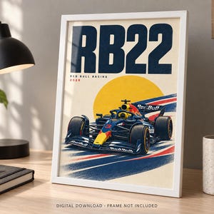 May include: A framed poster featuring a dark blue and yellow Red Bull Racing Formula 1 car with the number 3, set against a large yellow circle. The text RB22, Red Bull Racing, and 2026 are printed in dark blue and red on a cream background.
