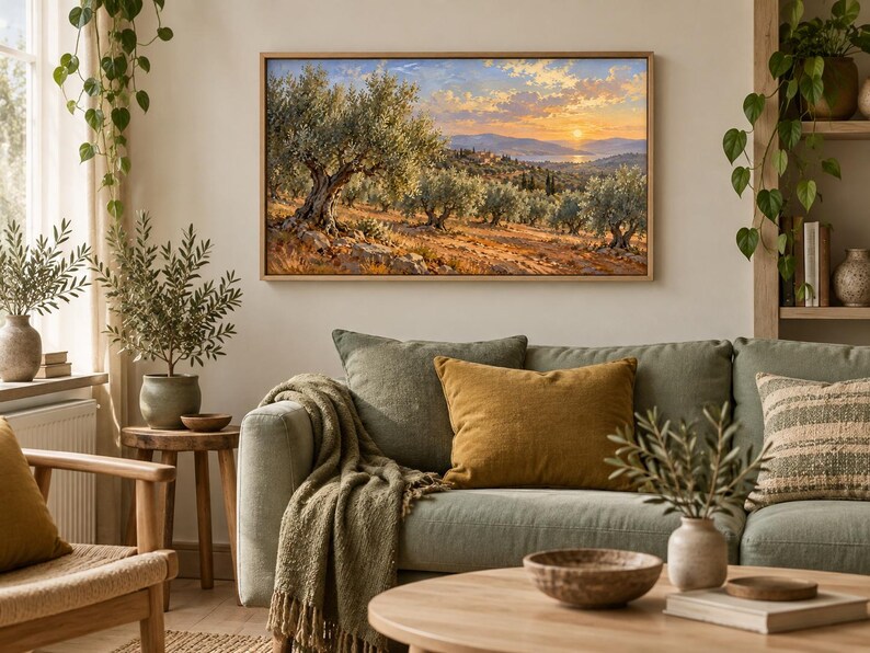 May include: A rectangular landscape painting in a light wood frame depicting an olive grove at sunset. The scene features gnarled olive trees with silvery-green leaves, golden-brown earth, and a distant view of hills and water under a warm sky.