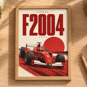 May include: A framed poster featuring a red Ferrari F2004 Formula 1 race car on a track. The text FERRARI F2004 and 2004 appears at the top. A large red circle is positioned behind the car. The poster is displayed in a light wood frame.