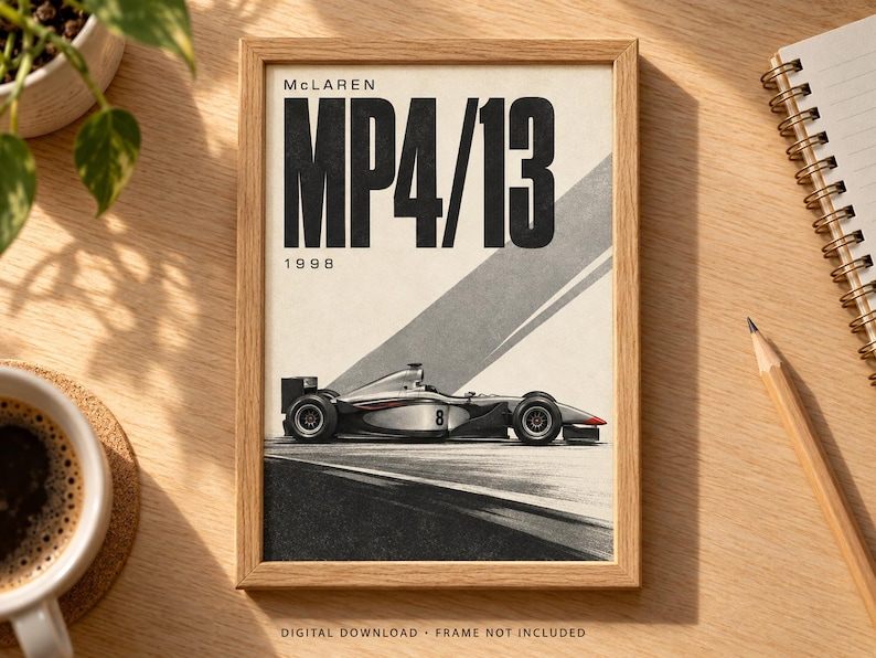 May include: A framed poster featuring a side profile of a silver and black McLaren MP4/13 Formula 1 race car with the number 8 on the side. The text reads McLaren MP4/13 and 1998. The design includes a diagonal gray stripe on a cream background.