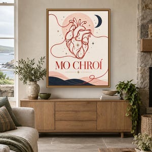 May include: A framed wall art print featuring a red anatomical heart illustration centered on a cream background. The design includes a dark blue crescent moon, stars, and wavy lines. The text MO CHRO&Iacute; is printed in red below the heart.