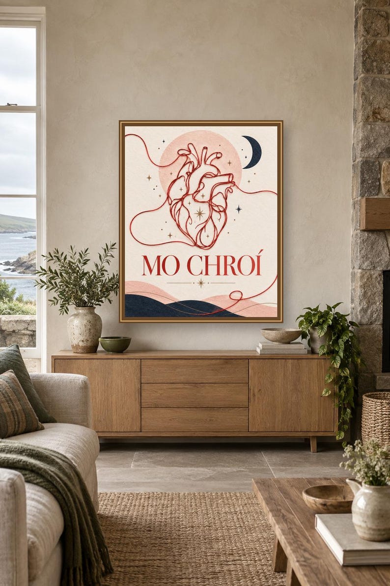 May include: A framed wall art print featuring a red anatomical heart illustration centered on a cream background. The design includes a dark blue crescent moon, stars, and wavy lines. The text MO CHRO&Iacute; is printed in red below the heart.