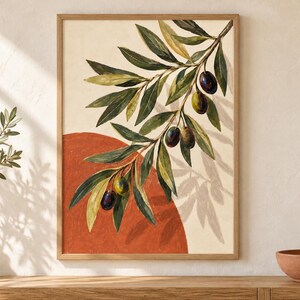May include: A framed wall art print featuring an olive branch with green and dark purple olives against a cream background. A large, solid terracotta-colored semi-circle sits behind the branch, which casts a soft, detailed shadow on the canvas.