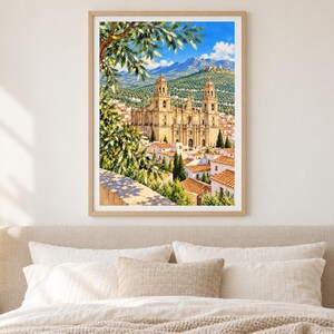 May include: A framed vertical wall art print depicting a sunlit Mediterranean landscape with a large stone cathedral featuring two towers, surrounded by white buildings with terracotta roofs, set against blue mountains and an olive tree branch.