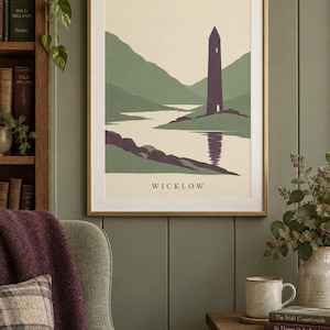 Peut inclure: Une impression d'art encadr&eacute;e repr&eacute;sentant un paysage stylis&eacute; de Wicklow, en Irlande. L'illustration montre une haute tour ronde violet fonc&eacute; situ&eacute;e au bord d'un lac, entour&eacute;e de collines vertes et d'une &eacute;tendue d'eau calme, avec le texte WICKLOW en bas.