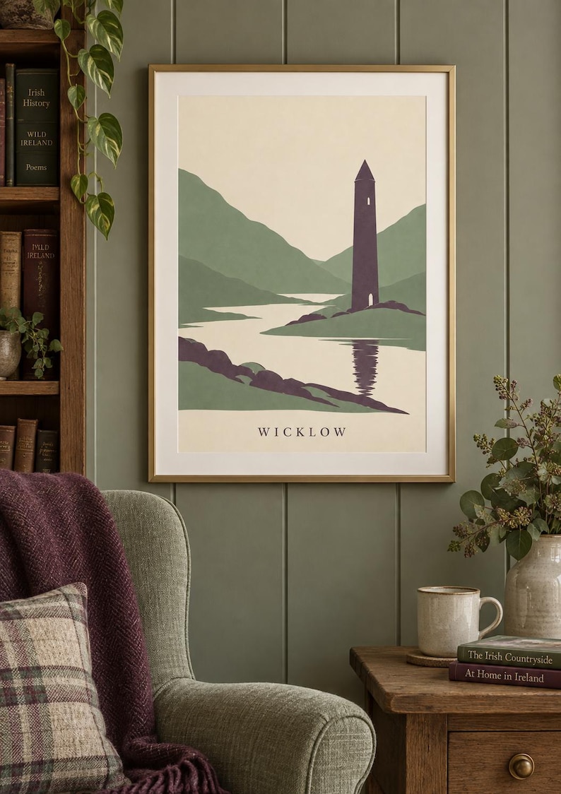 Peut inclure: Une impression d'art encadr&eacute;e repr&eacute;sentant un paysage stylis&eacute; de Wicklow, en Irlande. L'illustration montre une haute tour ronde violet fonc&eacute; situ&eacute;e au bord d'un lac, entour&eacute;e de collines vertes et d'une &eacute;tendue d'eau calme, avec le texte WICKLOW en bas.