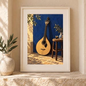 Pode incluir: Uma impress&atilde;o de arte emoldurada retratando uma guitarra portuguesa de cor clara encostada a uma parede azul vibrante. Ao lado do instrumento, h&aacute; um pequeno banco de madeira com um copo de caf&eacute; escuro e um jarro de cer&acirc;mica.