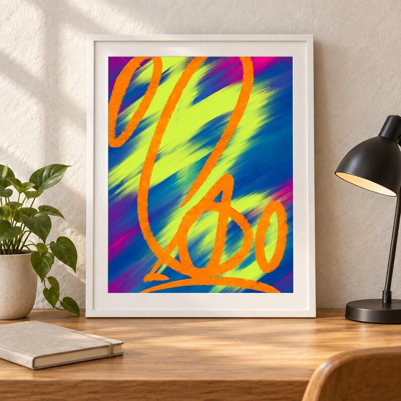 May include: A framed abstract print featuring bold orange calligraphic lines layered over a vibrant background of diagonal streaks in neon yellow, deep blue, and magenta. The artwork is enclosed in a simple white frame, showcasing a high-contrast composition with fluid, hand-drawn style strokes that create a sense of movement across the colourful, textured surface.