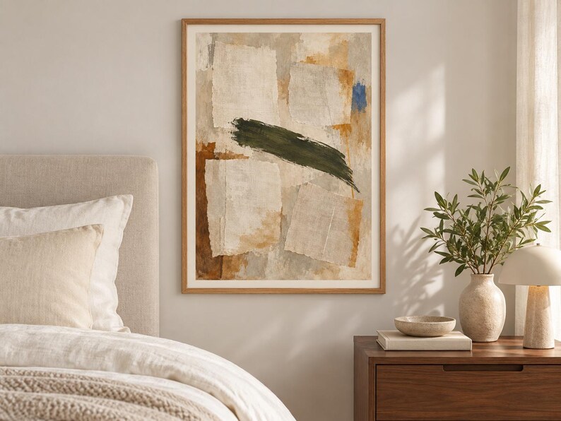 May include: A framed abstract wall art print featuring layered, torn-paper-style rectangular shapes in shades of beige, cream, and tan, accented by a bold, horizontal dark green brushstroke and a small patch of vibrant blue paint.