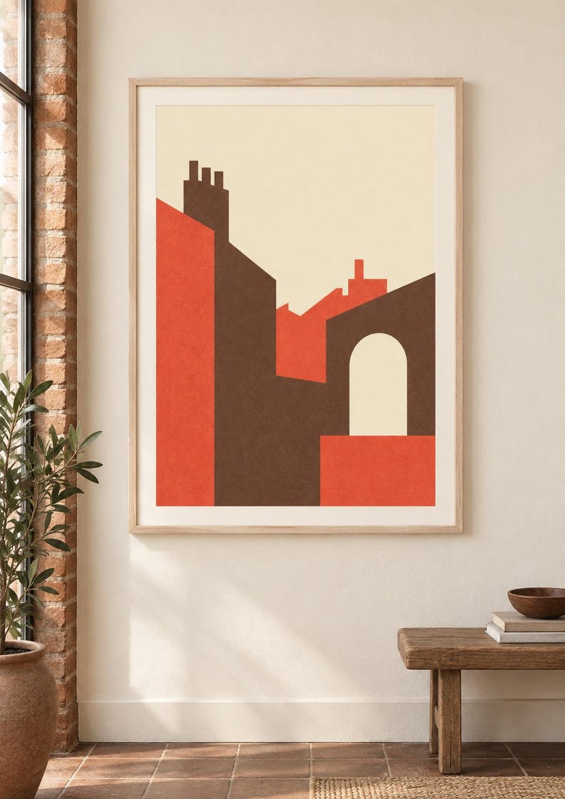 K&ouml;nnte beinhalten: Ein gerahmter Wandkunstdruck mit einer geometrischen architektonischen Komposition. Das Design zeigt flache Formen in Dunkelbraun, leuchtendem Orange und Creme, die stilisierte Geb&auml;udesilhouetten mit einem zentralen Torbogen darstellen.