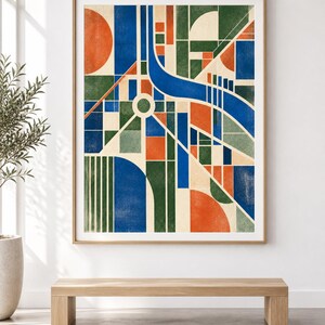 May include: A framed wall art print featuring a geometric abstract composition. The design consists of intersecting blue, green, and orange shapes, including circles, rectangles, and lines, set against a cream-coloured background within a light wood frame.