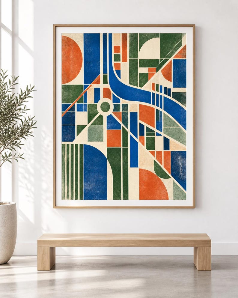 May include: A framed wall art print featuring a geometric abstract composition. The design consists of intersecting blue, green, and orange shapes, including circles, rectangles, and lines, set against a cream-coloured background within a light wood frame.