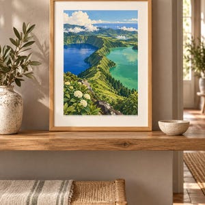 Puede incluir: Una l&aacute;mina de arte paisaj&iacute;stico enmarcada que muestra una vista elevada de dos lagos de cr&aacute;ter volc&aacute;nico adyacentes, uno azul profundo y otro turquesa, separados por una cresta verde con hortensias blancas en primer plano.