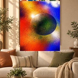 Op de afbeelding: Een rechthoekige wandkunstprint met een centrale donkere bol omringd door een levendige, met spuitverf bewerkte achtergrond. De kleuren gaan over van dieprood en oranje aan de linkerkant naar helderblauw en wit aan de rechterkant, wat een kosmisch effect cre&euml;ert.
