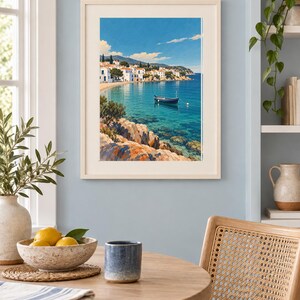 May include: A framed wall art print depicting a coastal Mediterranean scene with a small blue boat floating on clear turquoise water, rocky foreground cliffs, and a village of white buildings with orange roofs under a bright blue sky.
